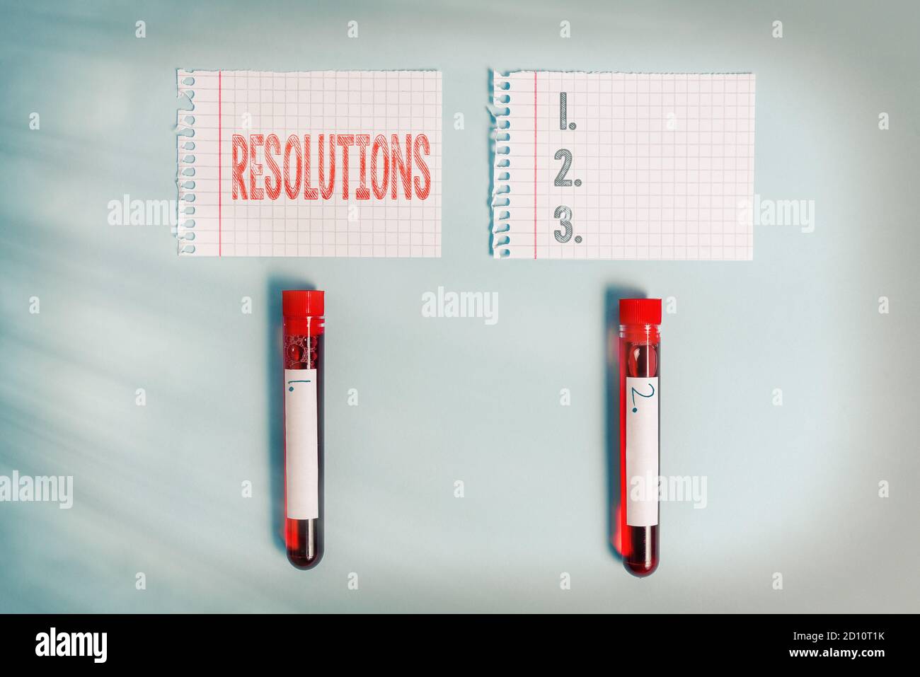 Writing note showing Resolutions. Business concept for the act of analyzing a complex notion into simpler ones Blood sample vial medical accessories r Stock Photo