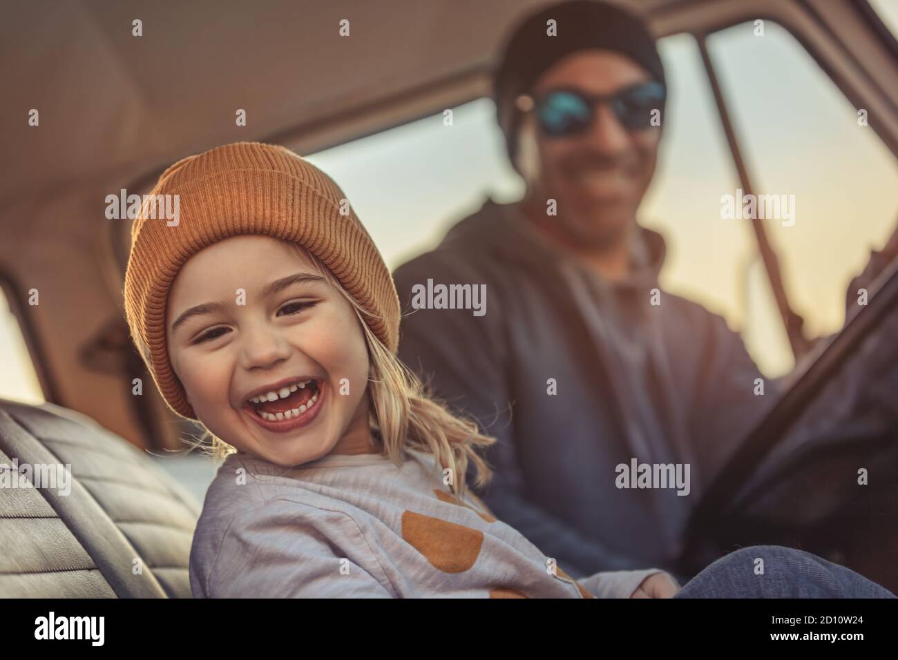 Cheerful Family Having Fun Together in the Car. Enjoying Road Trip. Father with Pleasure Teaching his Little Son to Driving Auto. Happy Fatherhood. Stock Photo
