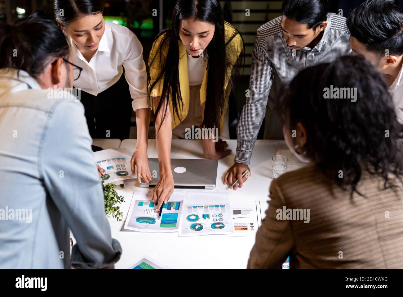 Work late concept of Interracial asian business team brainstorm idea at office meeting room at night. Work hard deadline and overtime working and new Stock Photo