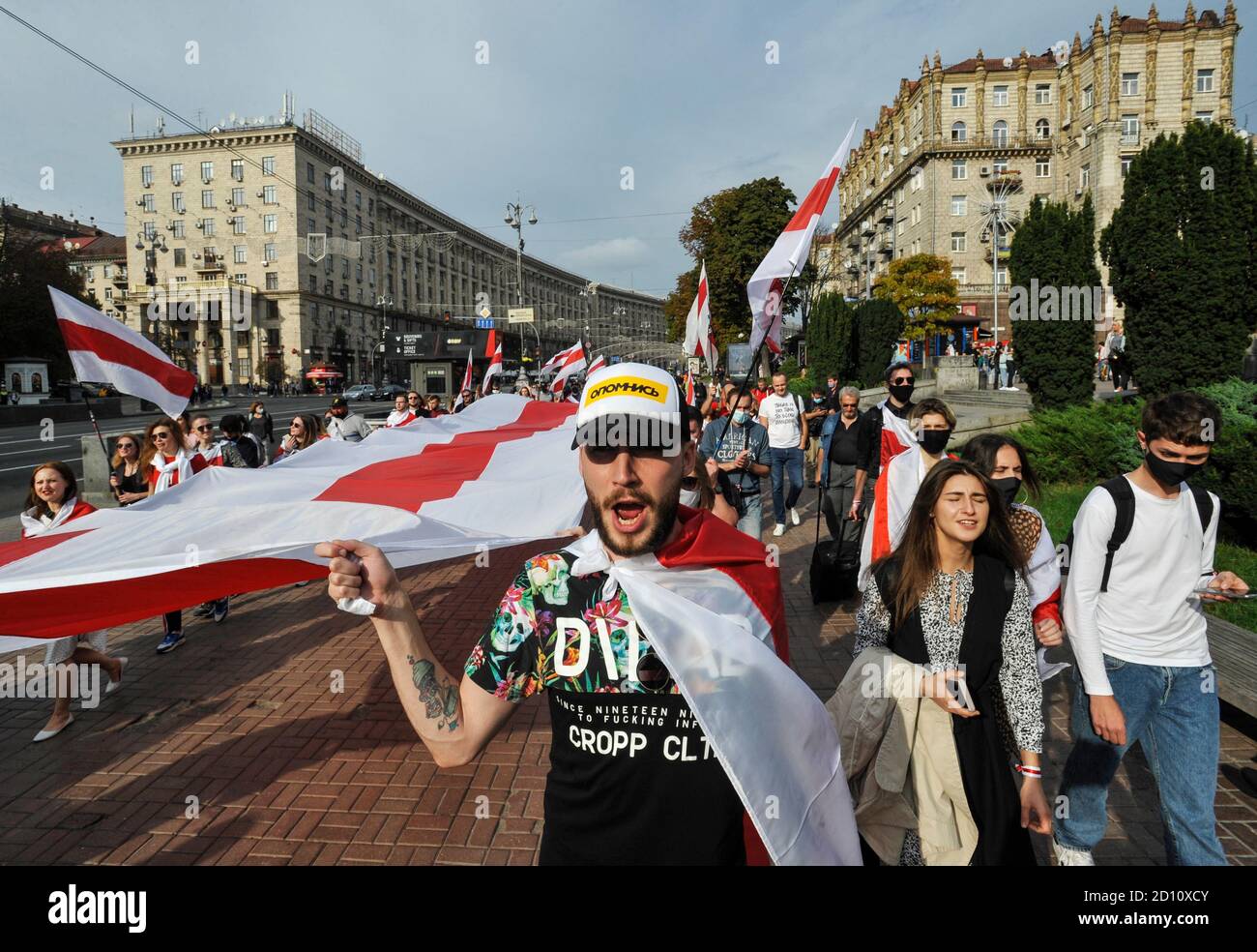 A protester holding on a giant white-red-white flag of Belarus ...