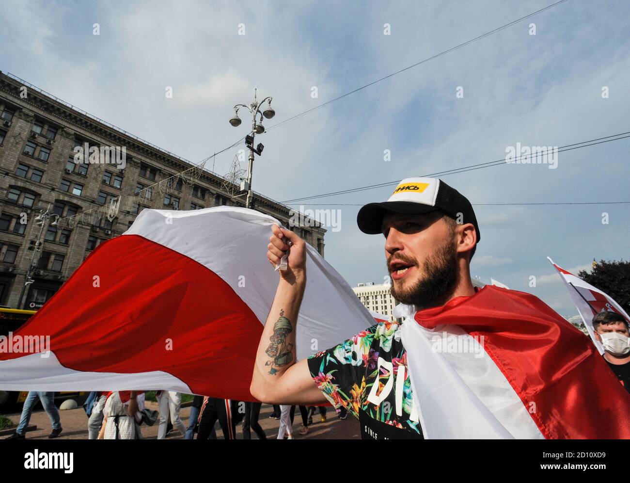 A protester holding on a giant white-red-white flag of Belarus ...