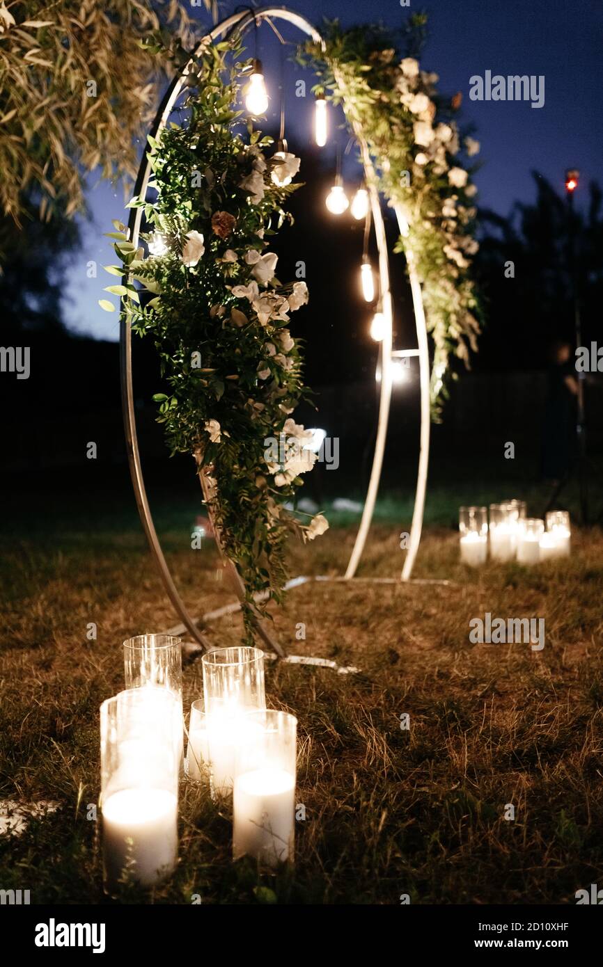 Circle wedding arch decorated with white flowers and lights. Wedding arch background Stock Photo