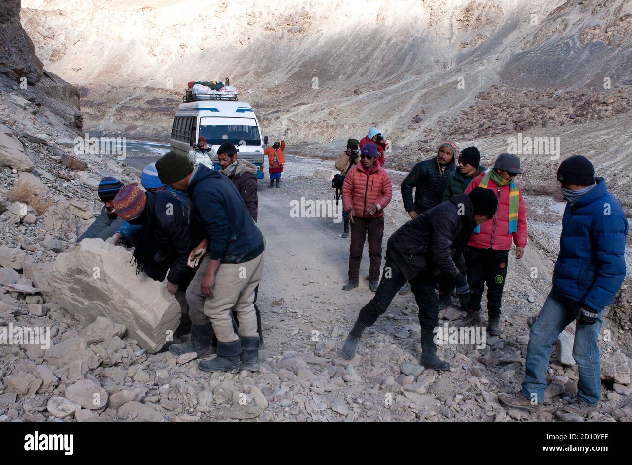 Men moving boulders, clearing road blocked due to land slide in a remote Himalayan high altitude road in Ladakh Stock Photo