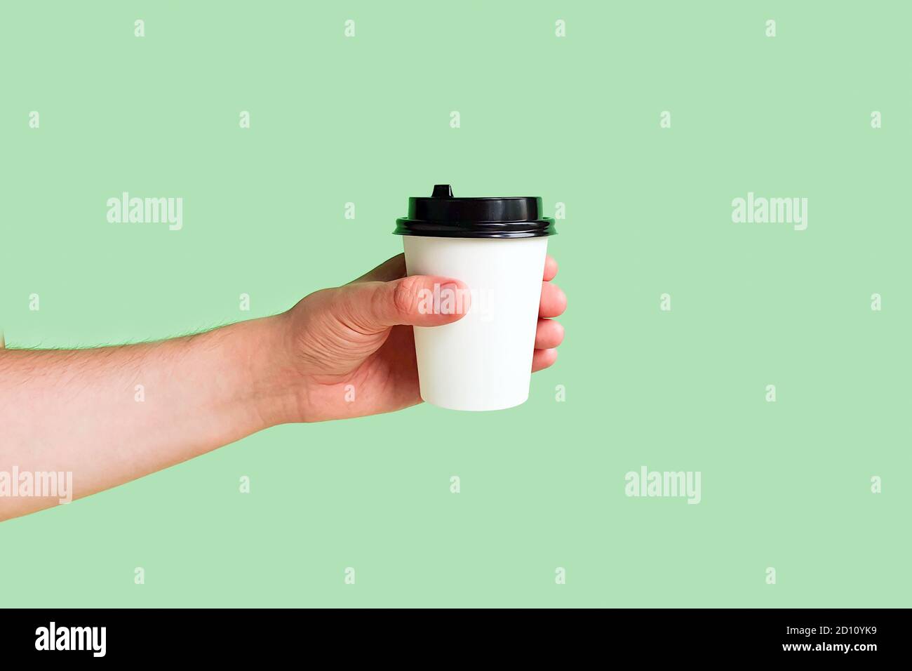 Download Mockup Of Male Hand Holding A Coffee Paper Cup On Light Green Background Take Away Cup With Plastic Lid Space For Text Copy Space Stock Photo Alamy