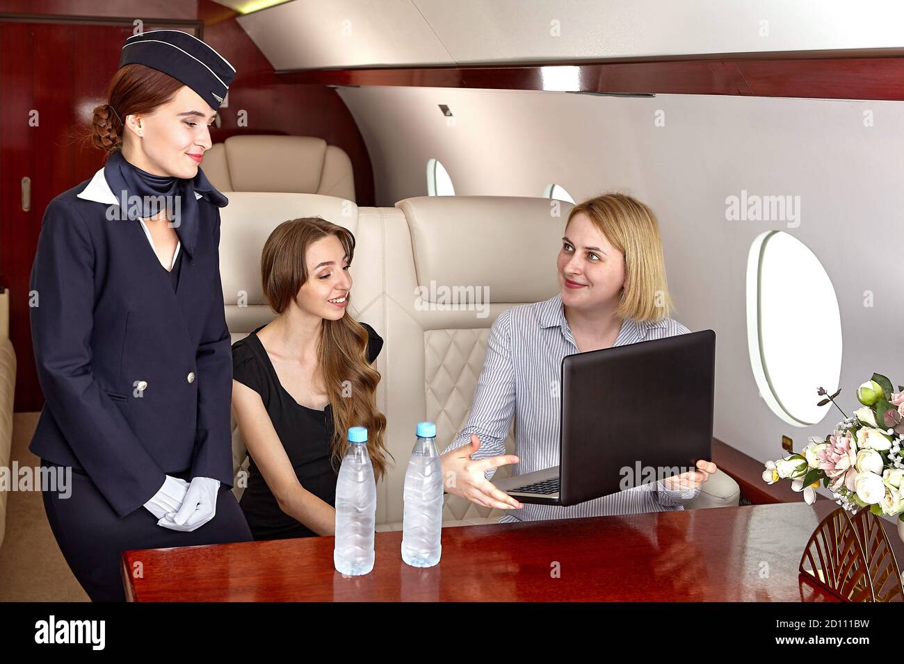 Cabin crew serves passengers inside the aircraft. A flight attendant or air hostess, is a member of the aircrew aboard commercial flights and business Stock Photo