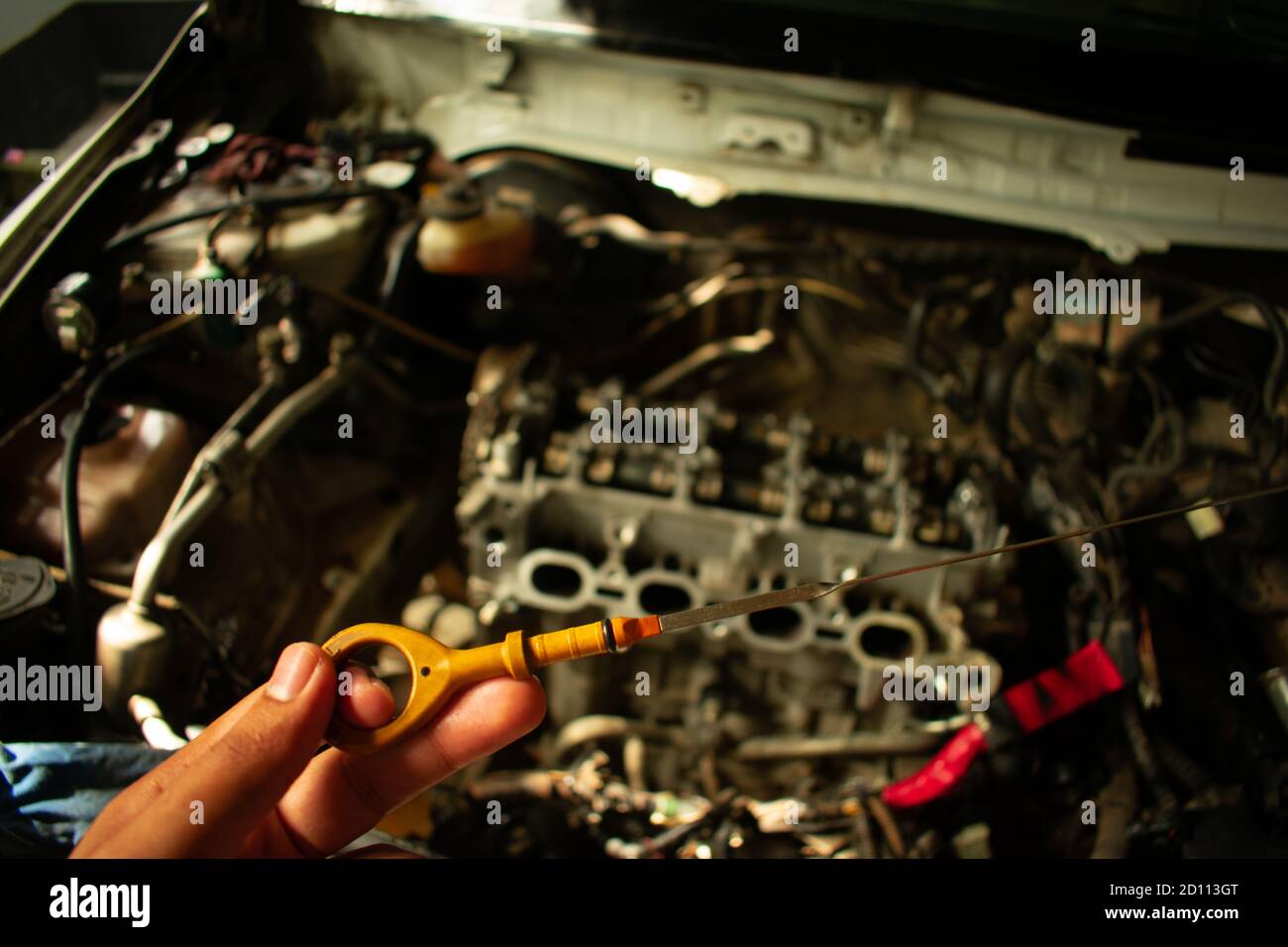 engine oil checker in a automobile center looking in the car engine inside Stock Photo