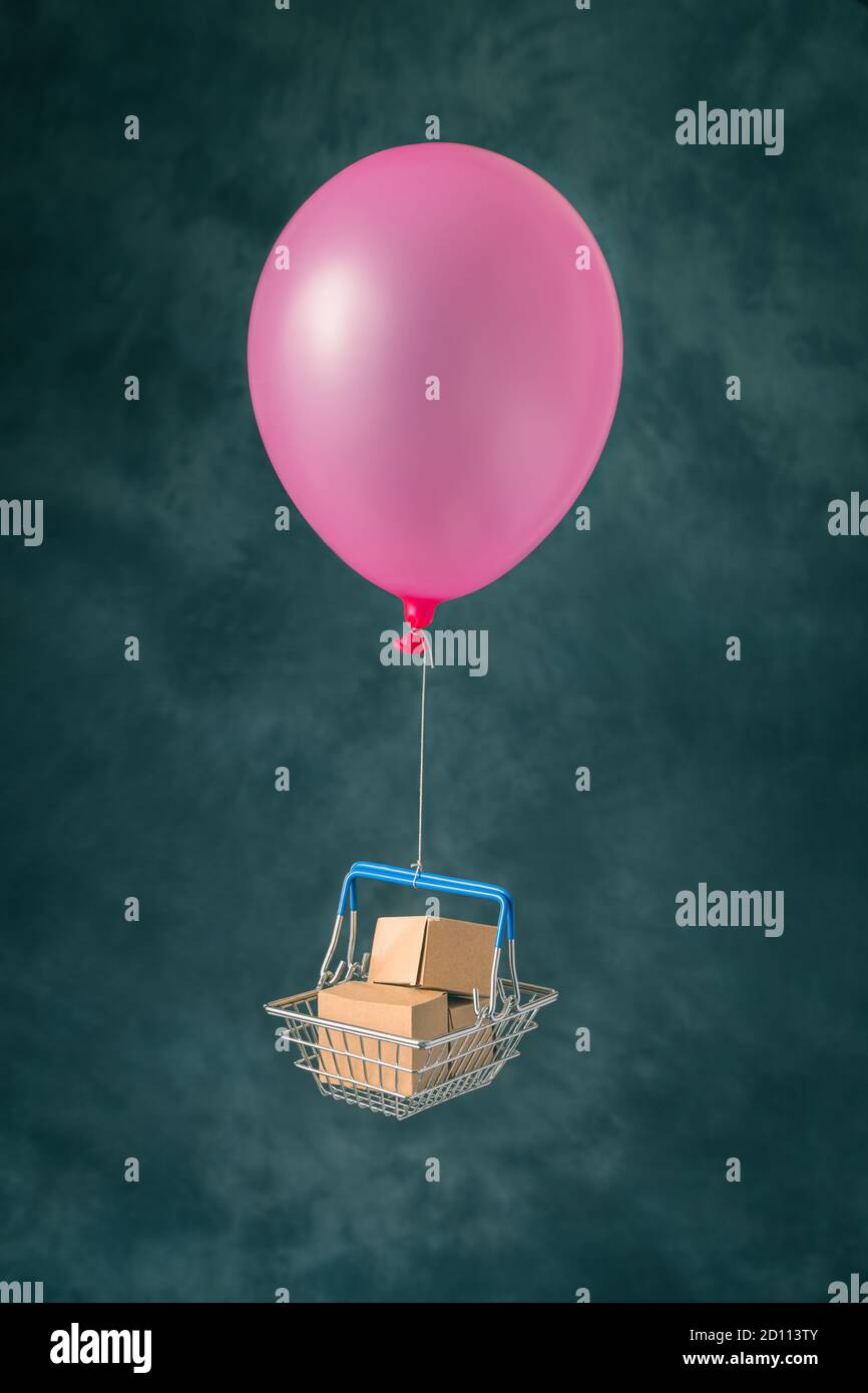 Shopping basket flying on balloon Stock Photo