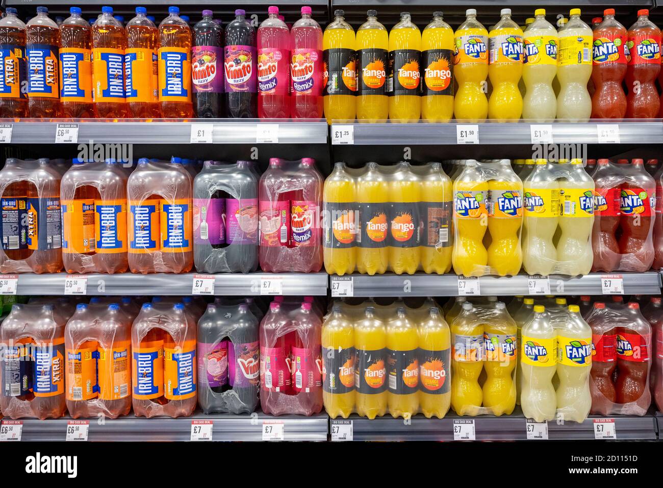 Bottles of 2 litre fizzy drinks on sale on a shelf in a supermarket in