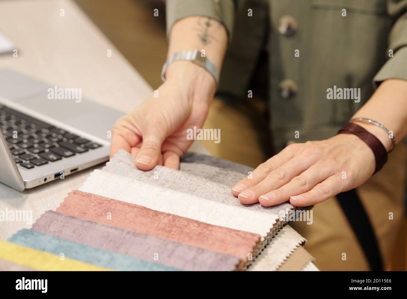 Hands of manager of studio of interior design looking through fabric samples Stock Photo
