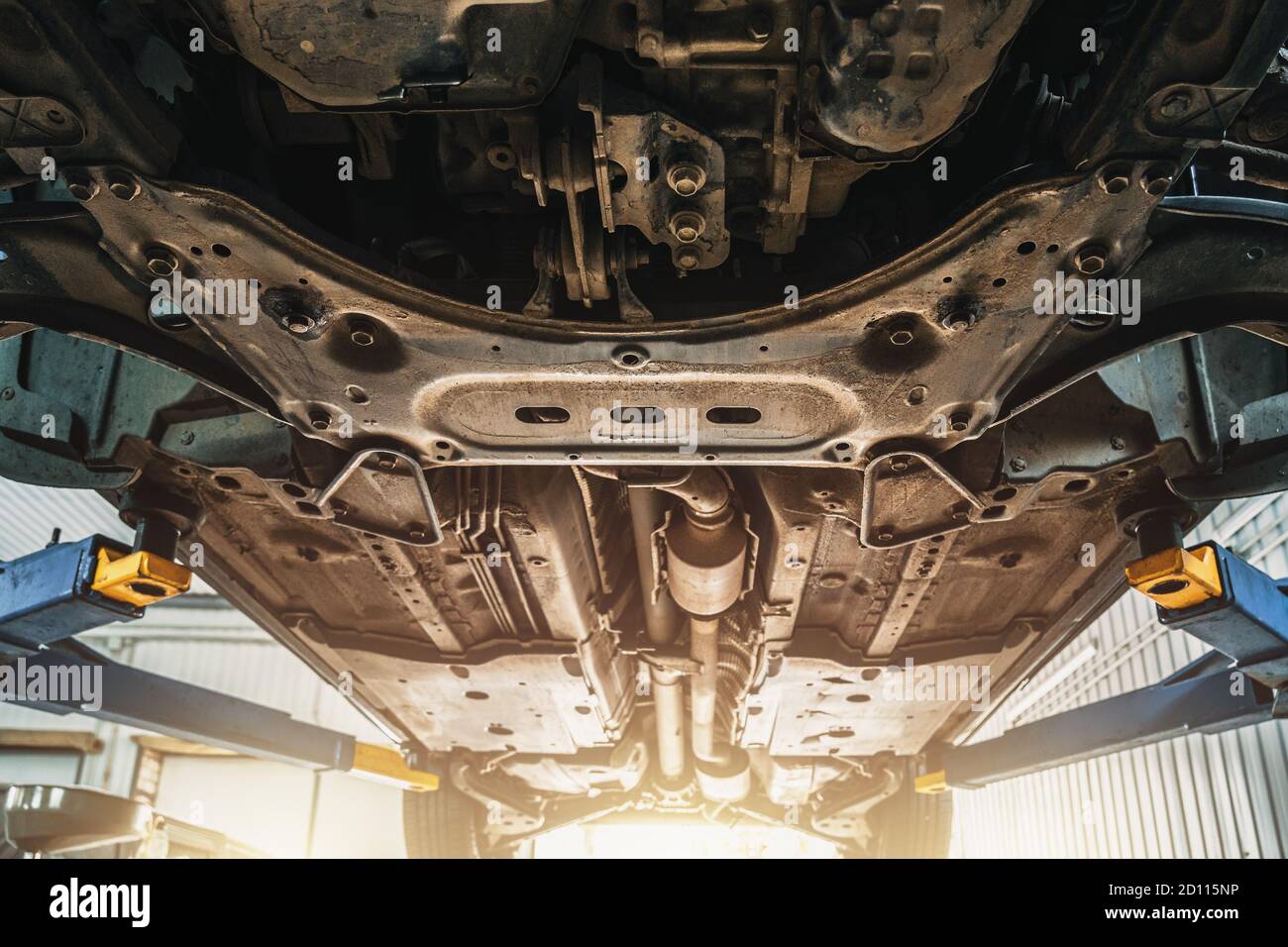 Car on lift in auto service for maintenance and repair, bottom view of car from below. Stock Photo