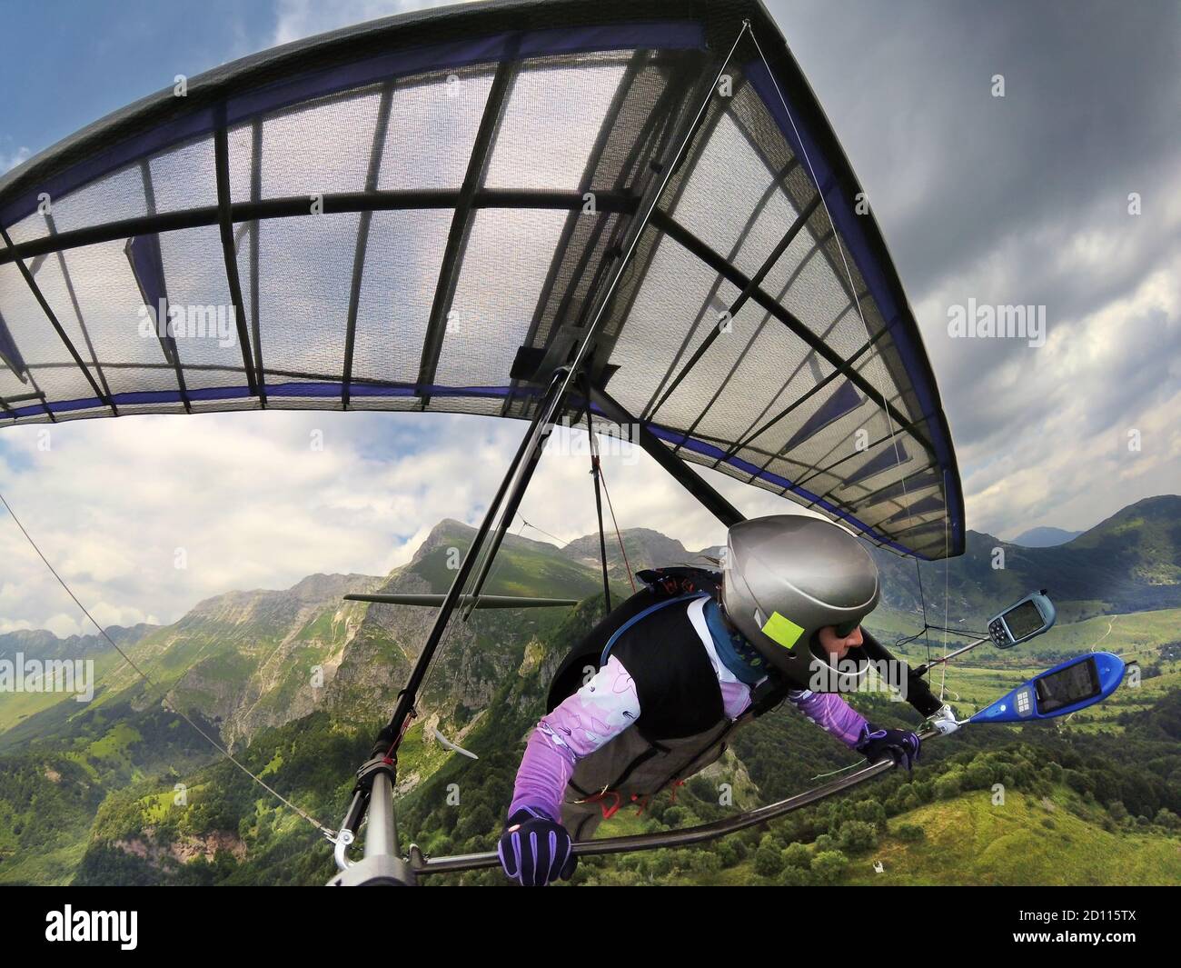 Hang glider pilot soars high above mountain peaks. Extreme sport in Soca valley, Slovenia Stock Photo