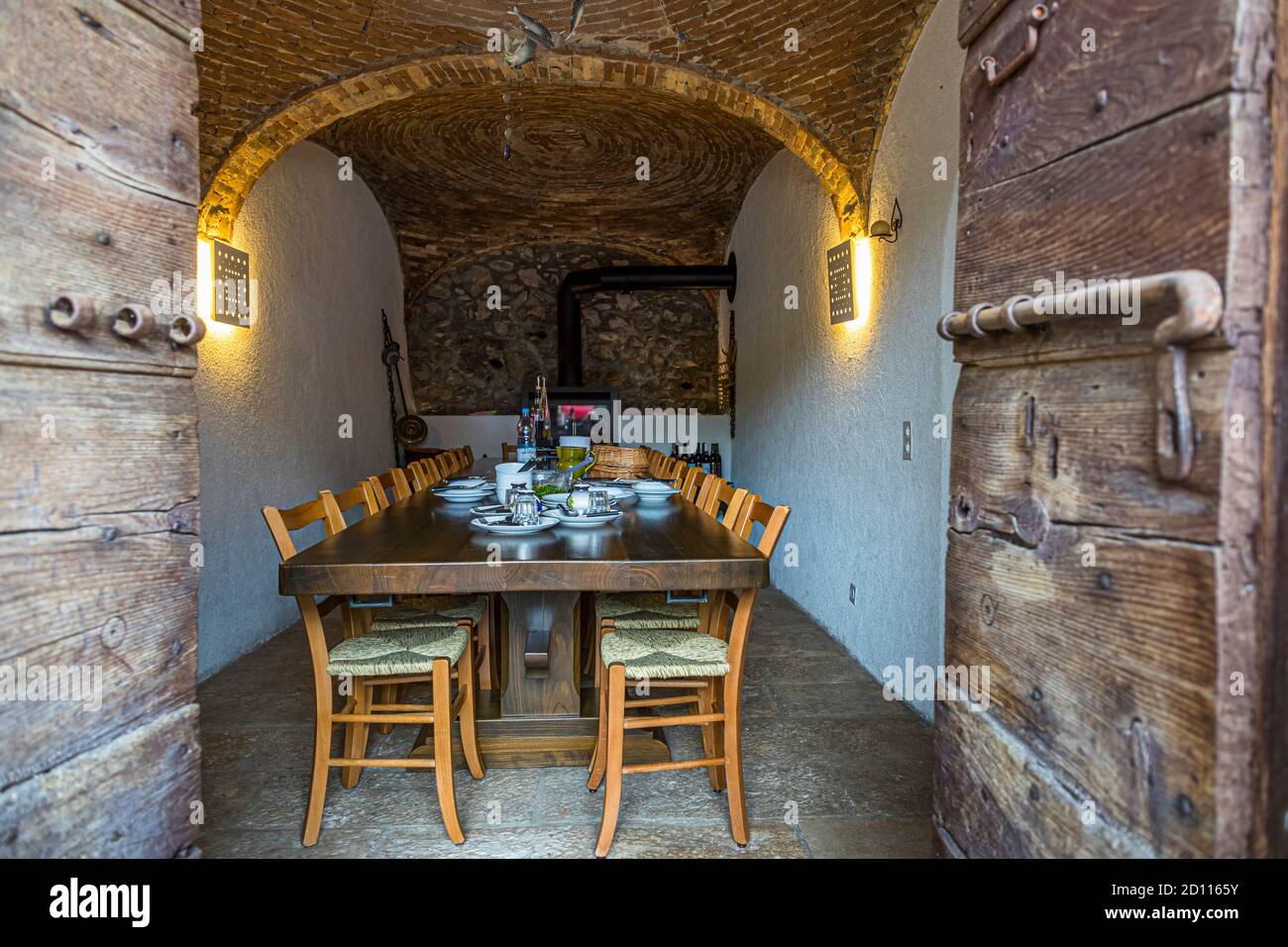 Culinary tour on Lake Lugano in Ticino, Circolo di Carona, Switzerland. The Cantine of Gabriela Monfredini in Melide. The cellars of the former natural cellar now house a kitchen and a dining room with a long table Stock Photo
