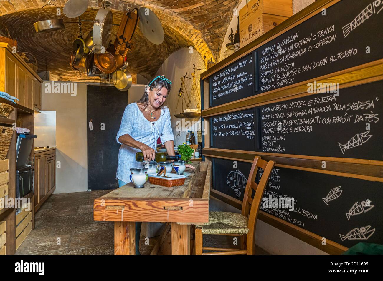 Culinary tour in Melide on Lake Lugano in Ticino, Circolo di Carona, Switzerland. Gabriella in the kitchen. Virtually galactic, large pots and pans float in the basement firmament Stock Photo