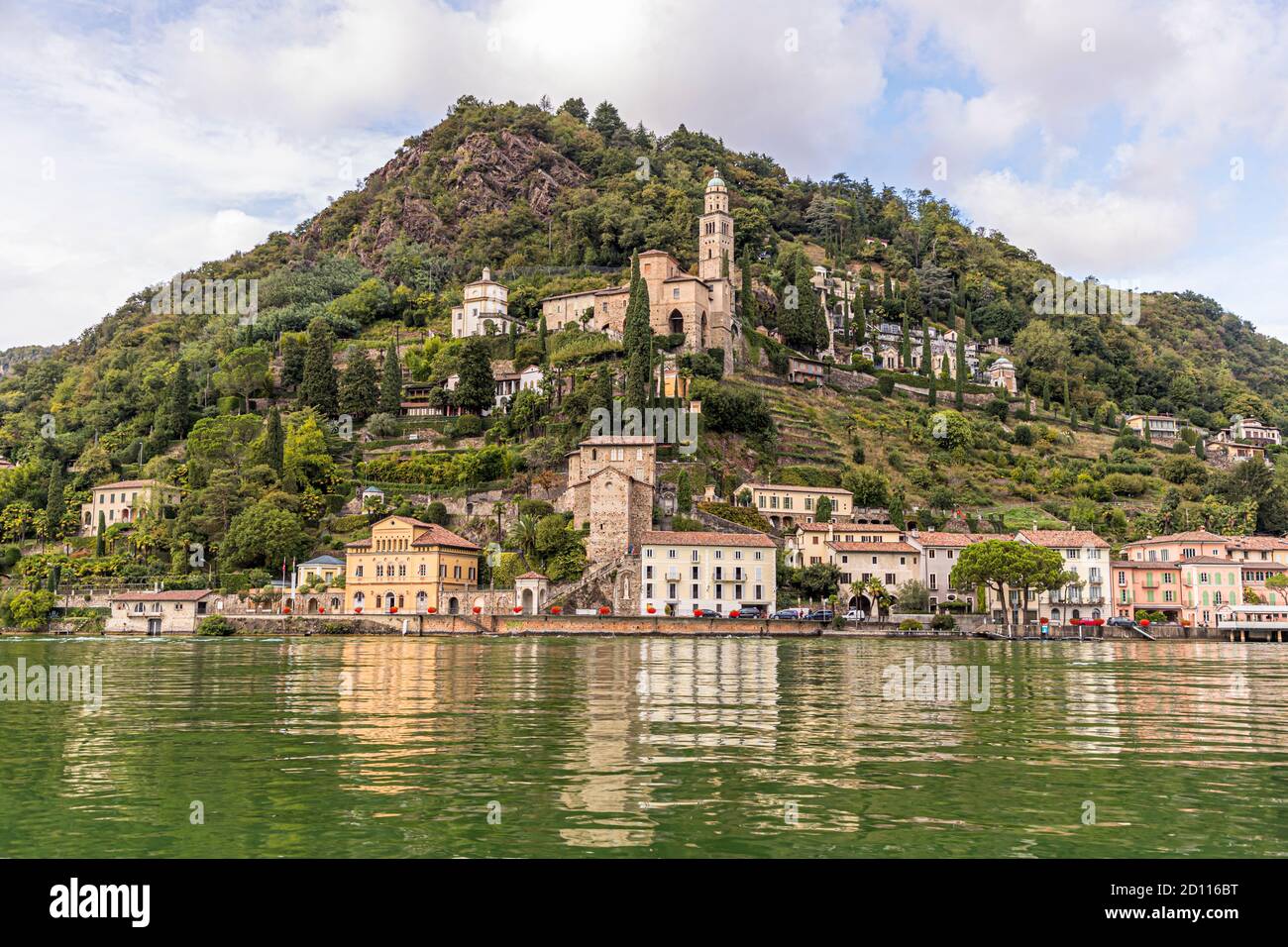 Culinary tour on Lake Lugano in Ticino, Circolo di Carona, Switzerland. Viewed from the water: The church of Santa Maria del Sasso of Morcote, with the historic old town below. Many small restaurants line the waterfront promenade Stock Photo