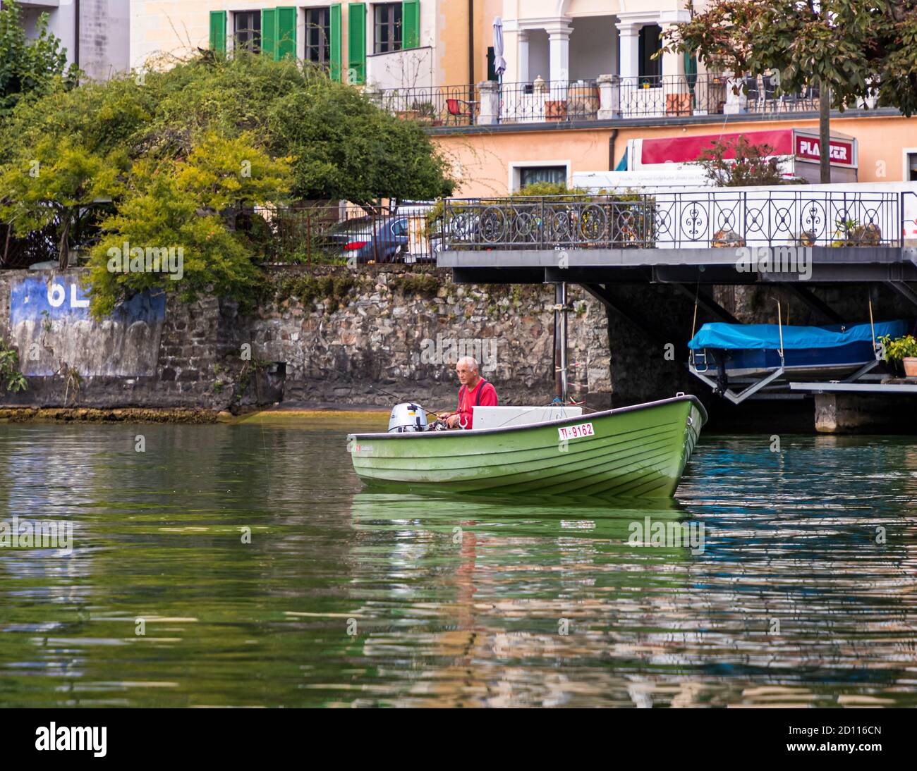 Angler in a boat on lake Lugano. Culinary tour on Lake Lugano in Ticino, Circolo di Carona, Switzerland Stock Photo