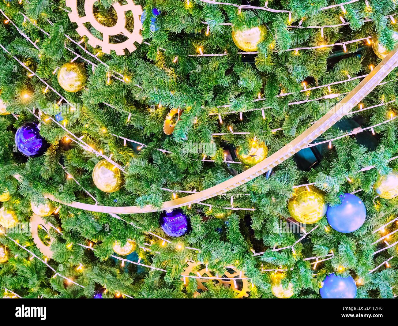 Christmas tree decorated with garlands and golden and blue balls. Full ...