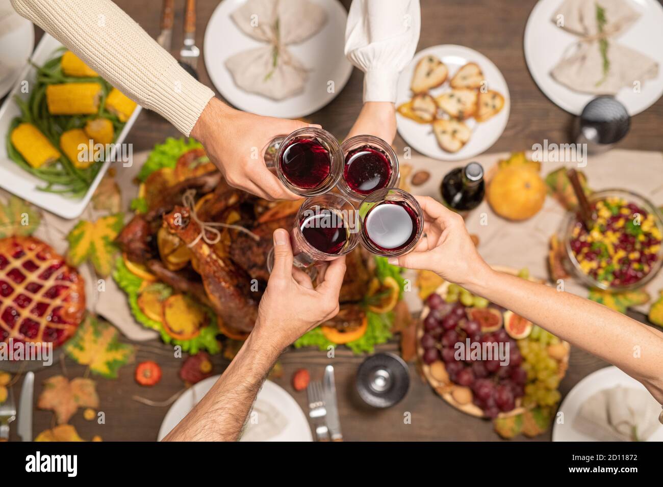 Overview of four glasses of red wine held by members of family during