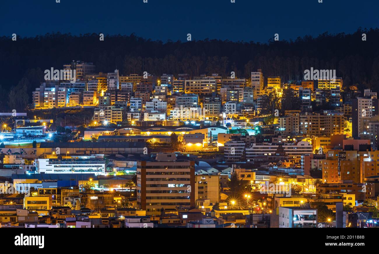 Aerial cityscape of modern apartment buildings at night, Quito, Ecuador. Stock Photo
