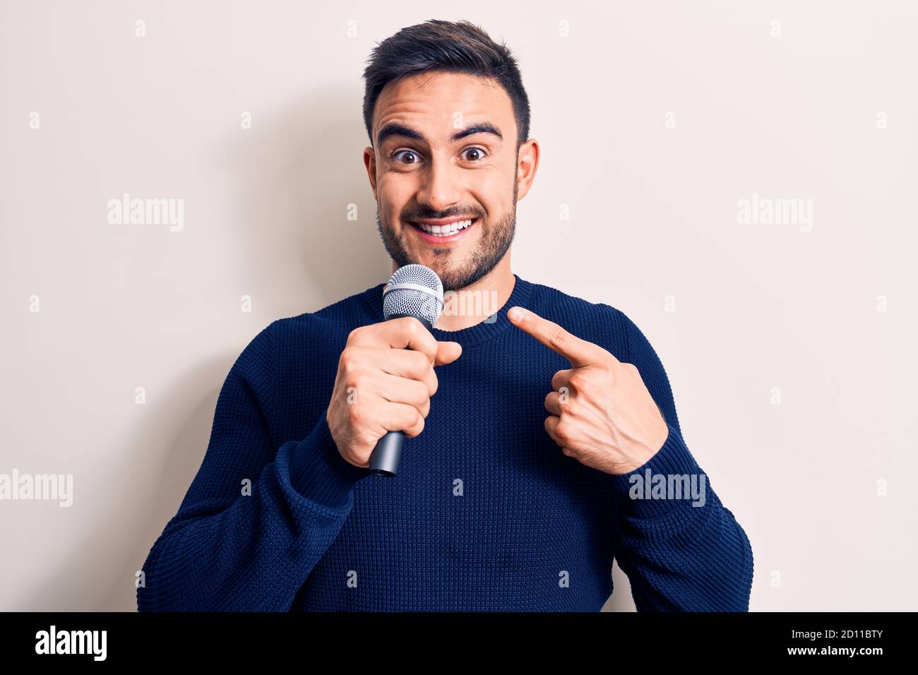Young handsome singer man with beard singing song using microphone over  white background smiling happy pointing with hand and finger Stock Photo -  Alamy