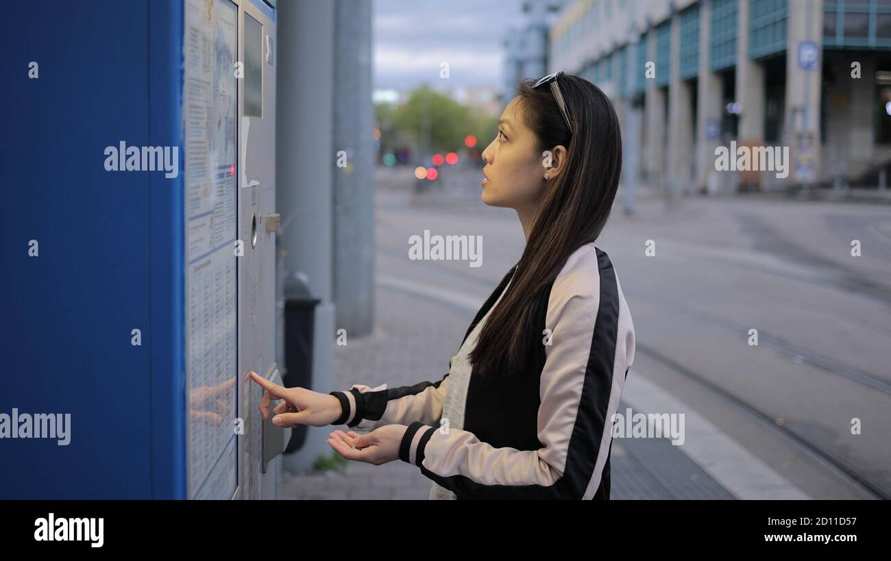 Young Asian woman buys a ticket for the tram Stock Photo - Alamy