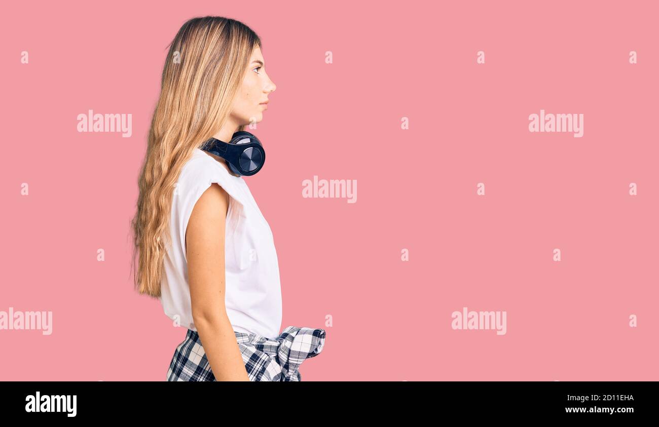 Beautiful caucasian woman with blonde hair listening to music wearing ...