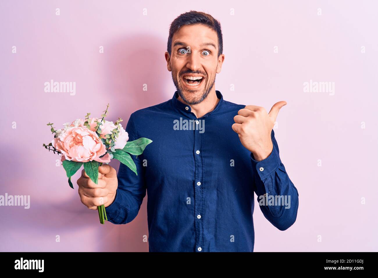 Young handsome romantic man holding beautiful bouquet of flowers over ...