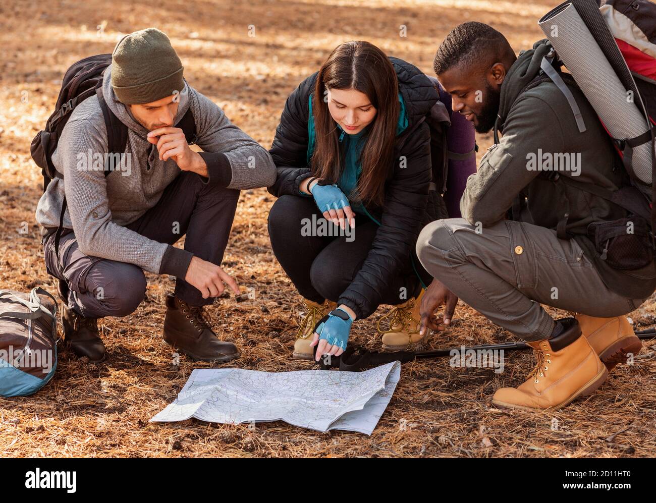 Confused hikers looking at map, lost in forest Stock Photo