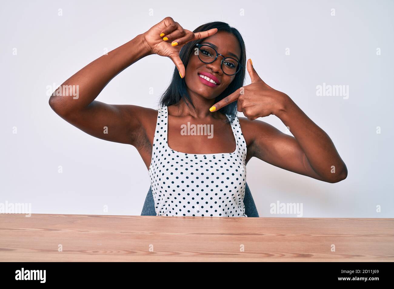Young african american woman wearing casual clothes and glasses sitting ...