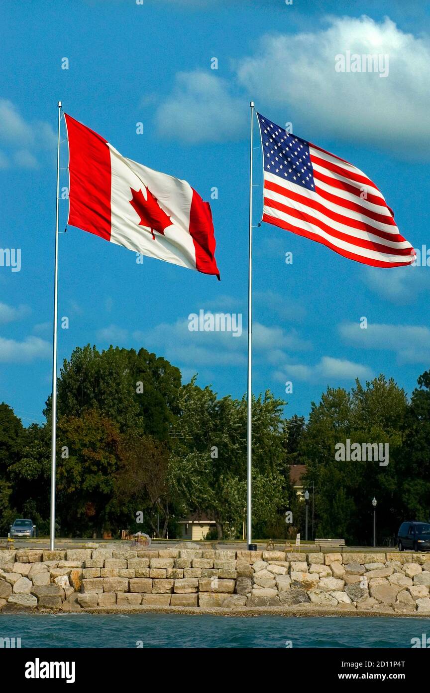 The American and Canadian flag fly side by side at Port Huron Michigan and Sarnia Ontario Canada Stock Photo