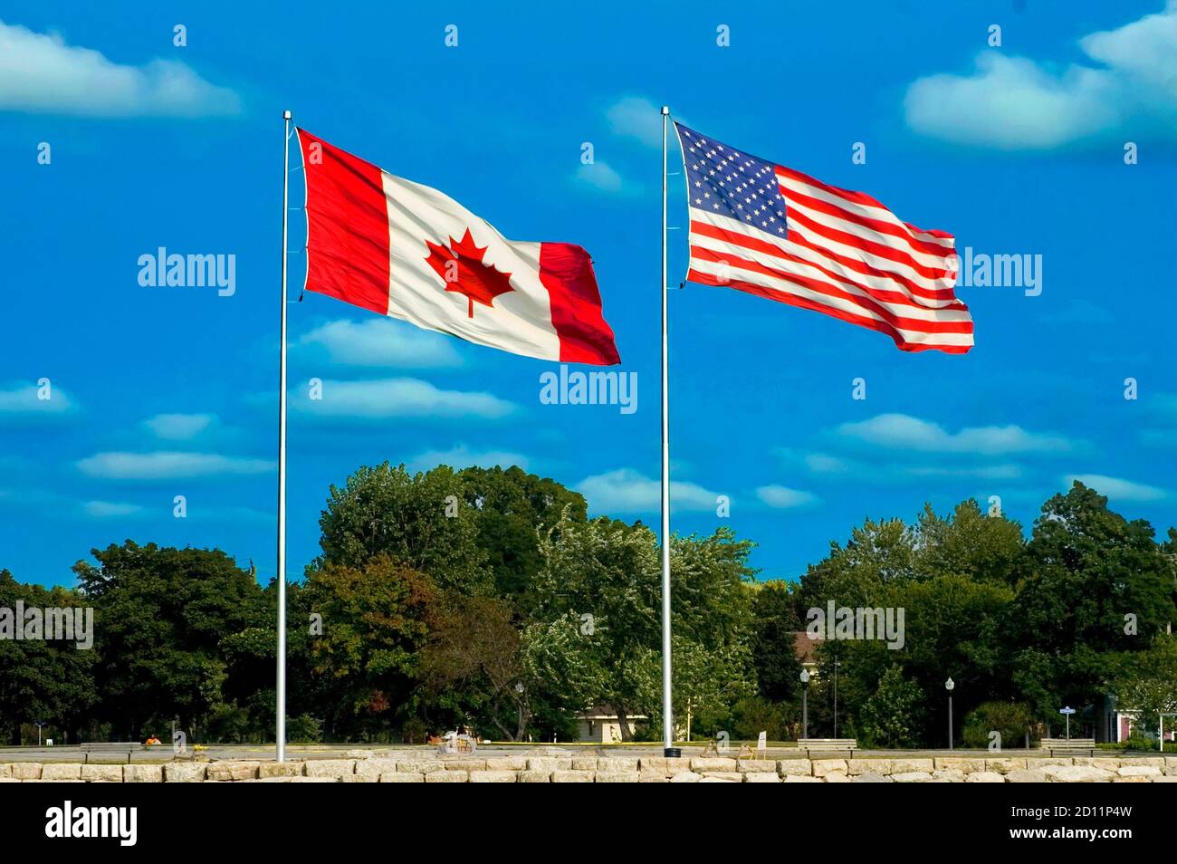 The American and Canadian flag fly side by side at Port Huron Michigan and Sarnia Ontario Canada Stock Photo