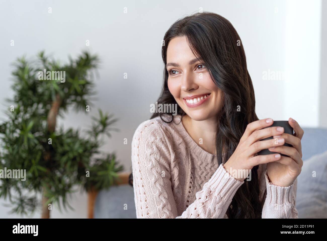 Young happy woman drinking tea on the in the morning. Beautiful female smile Stock Photo
