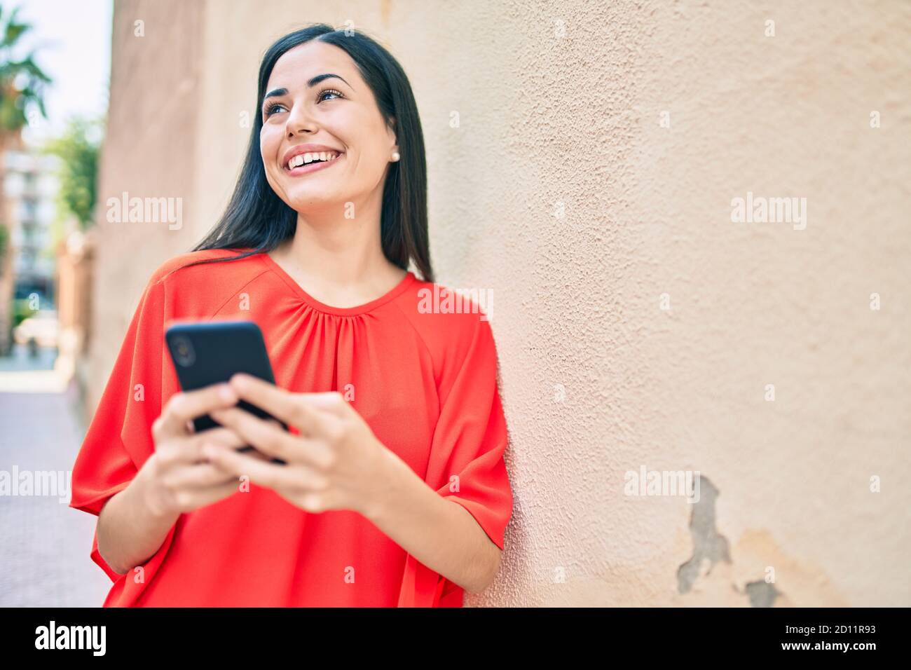Young latin girl smiling happy using smartphone at the city Stock Photo ...