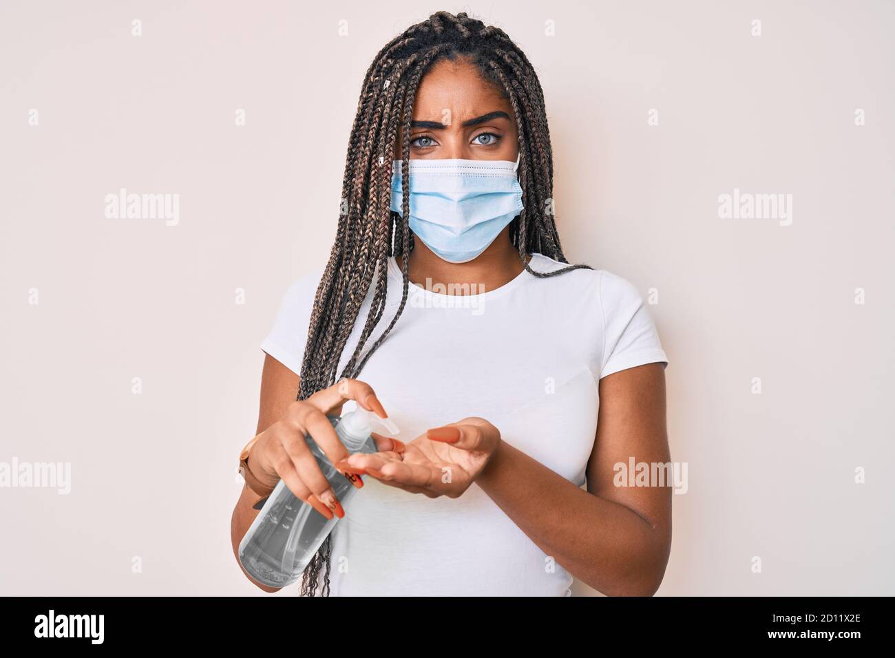 Young african american woman with braids wearing medical mask using ...