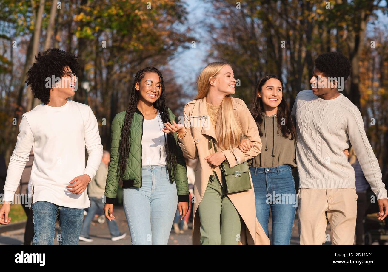 Positive students walking by park, spending weekend together Stock Photo