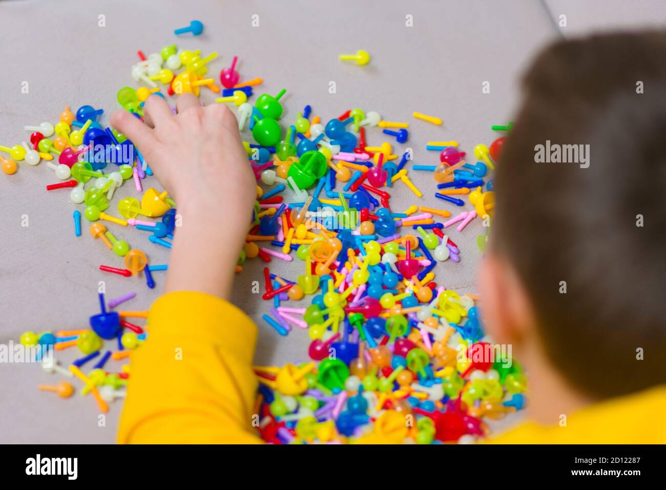 Child playing creative pin board game with colorful plasitc peaces
