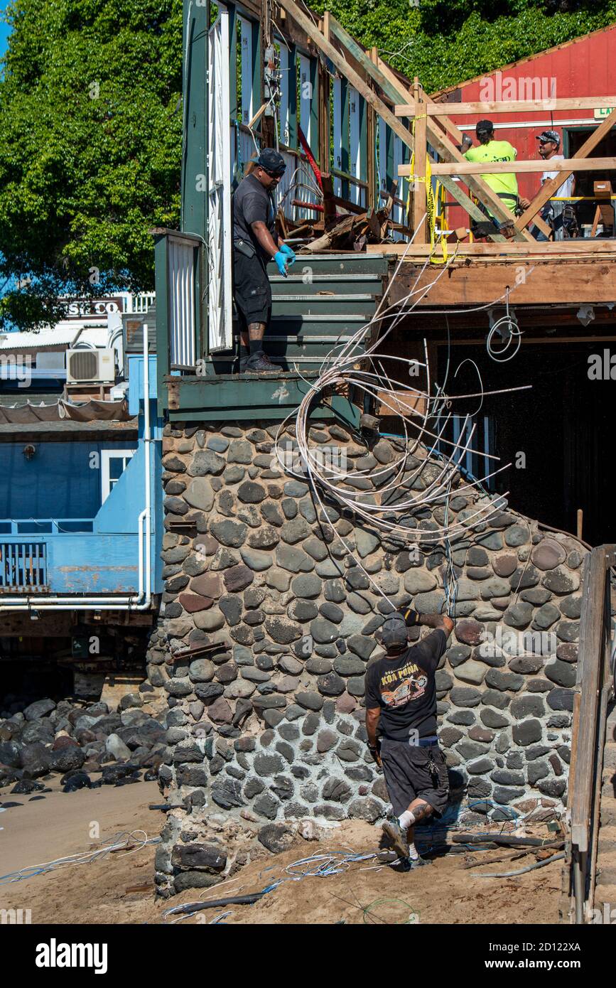 Maui, Hawaii. Construction worker handing material to another worker in