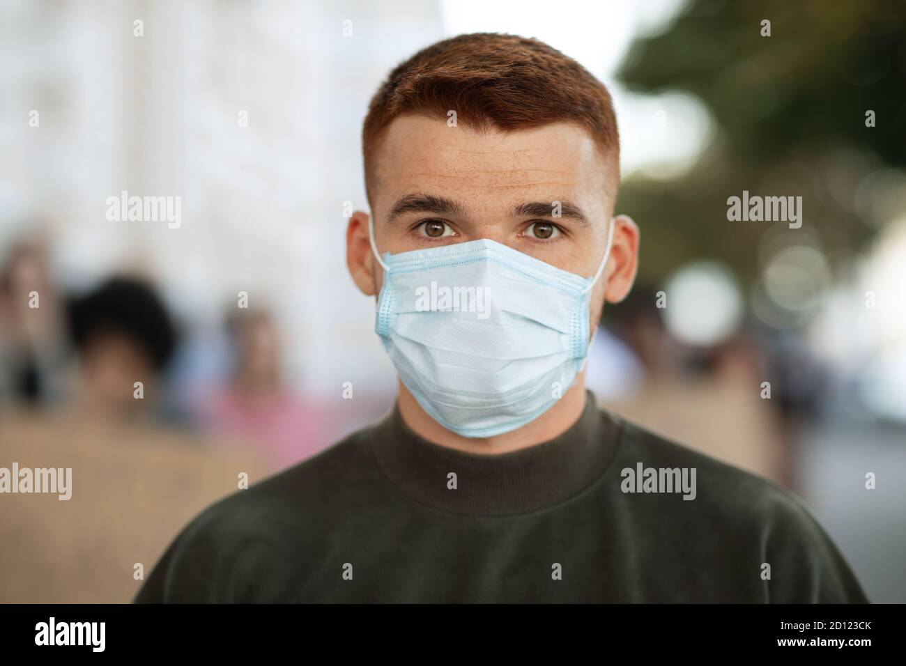 Guy in face mask over group of demonstrators Stock Photo
