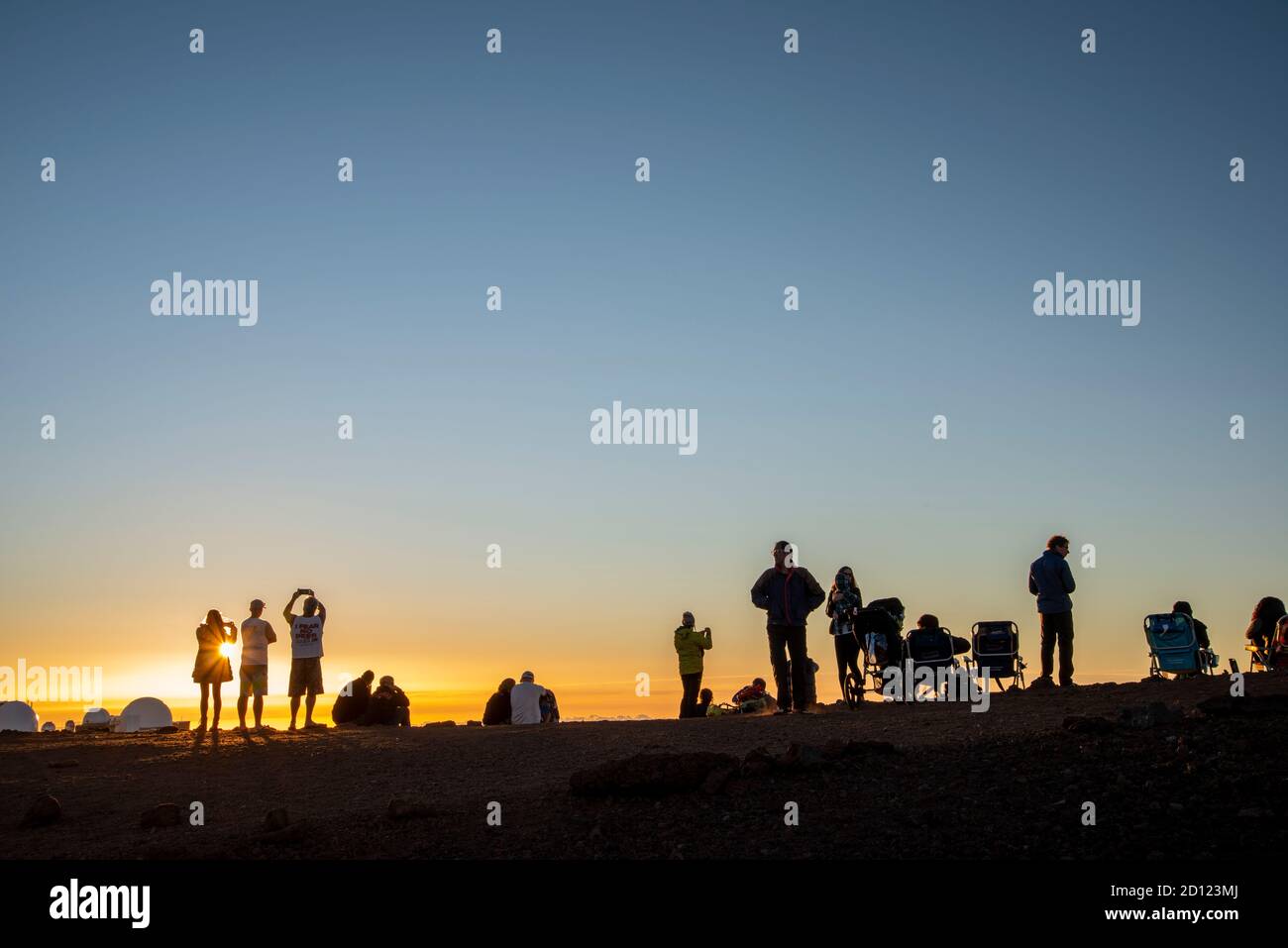 Maui, Hawaii.  Tourists on the Haleakala Crater in the Haleakala National Park watch the sunset while above the clouds. Stock Photo