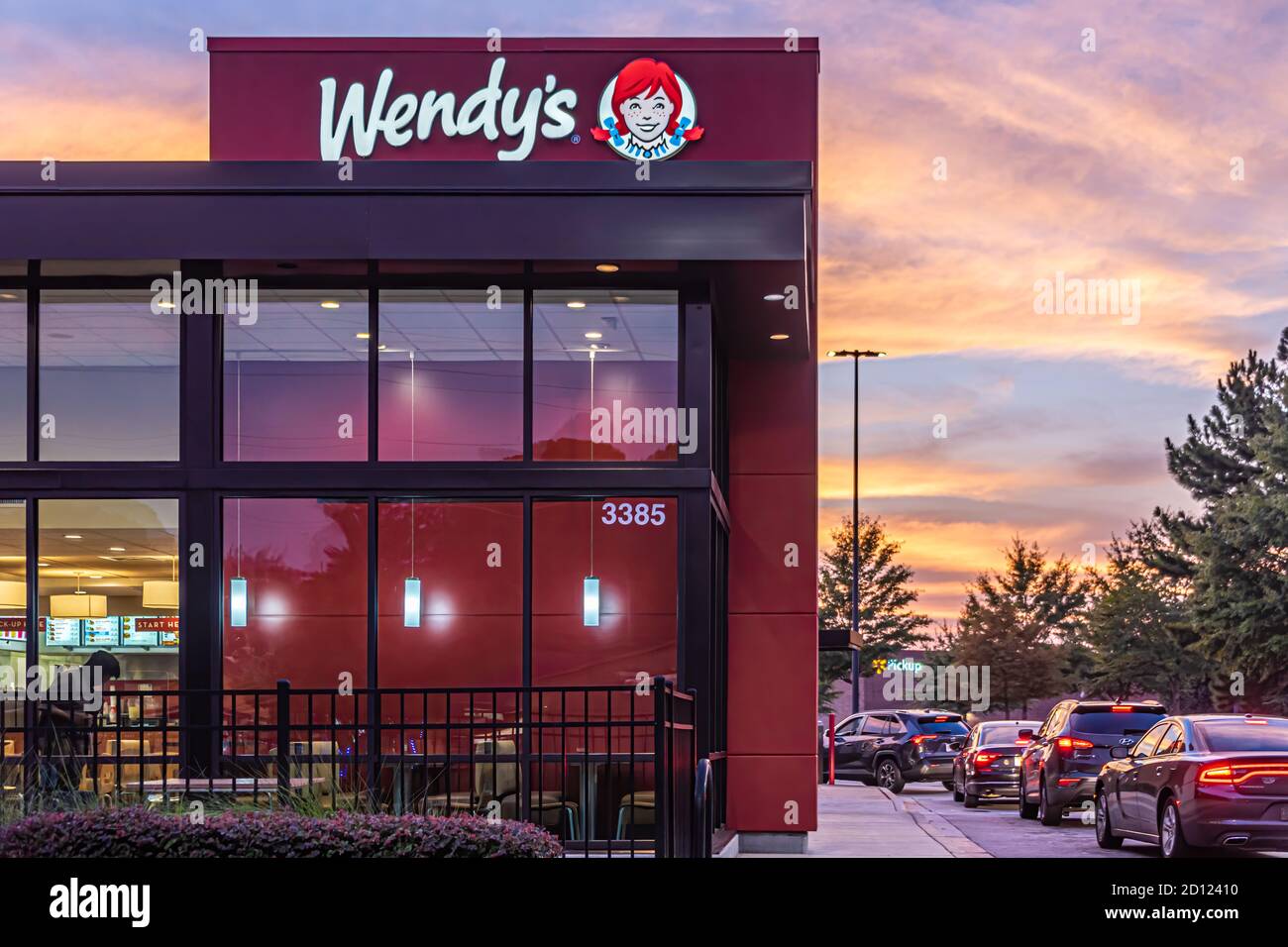 Wendy's fast-food hamburger chain restaurant with wrap-around drive-thru line at sunset in Snellville, Georgia. (USA) Stock Photo