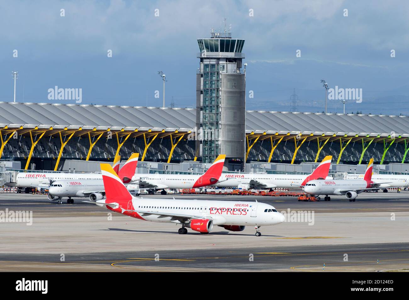 Multiple Iberia Express and Iberia Airlines aircraft lined up in Barajas Airport (LEMD) Terminal 4. Busy travel period in airline hub in Spain. Stock Photo