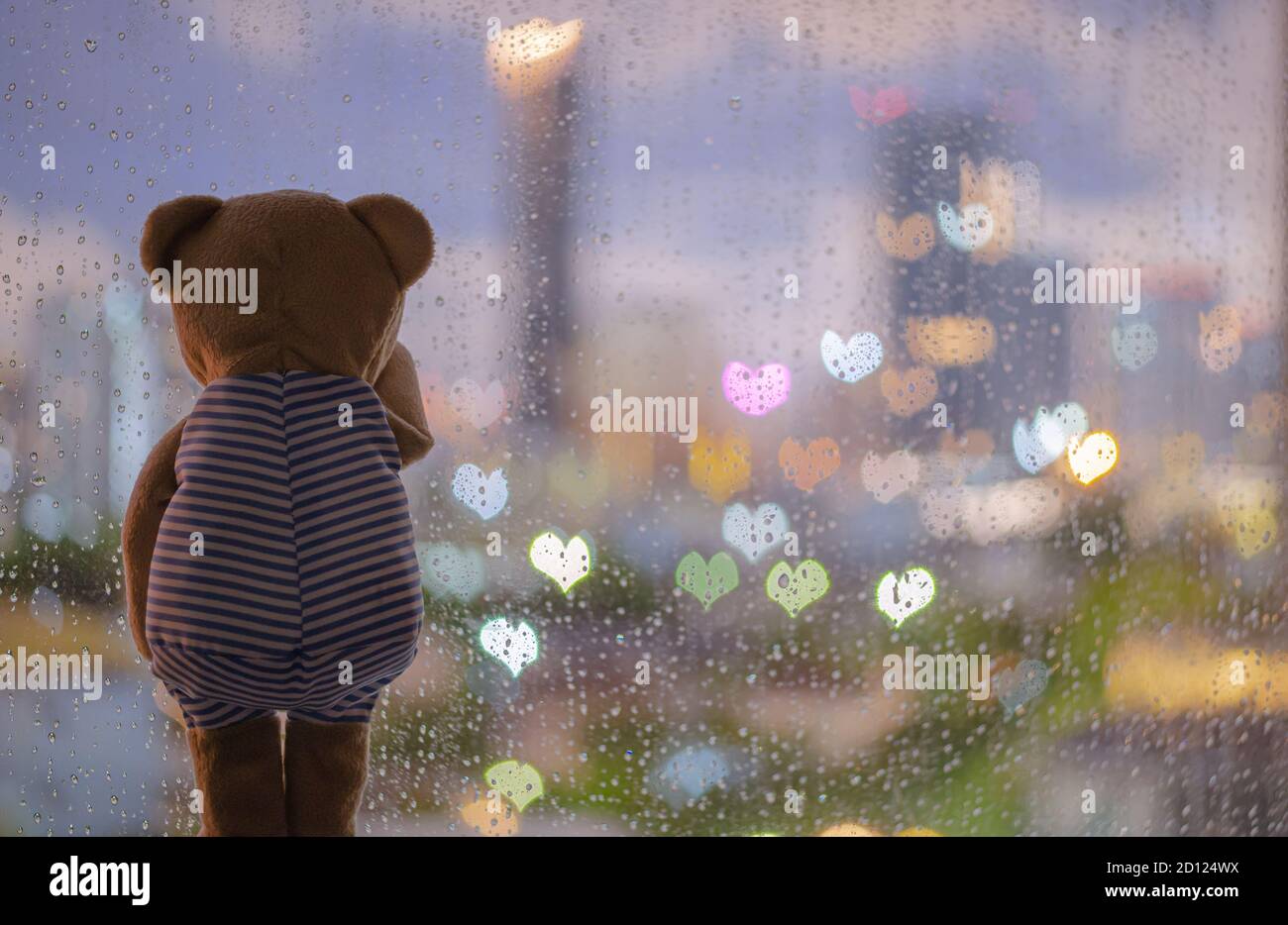 Teddy bear crying alone at window when raining with colorful love ...