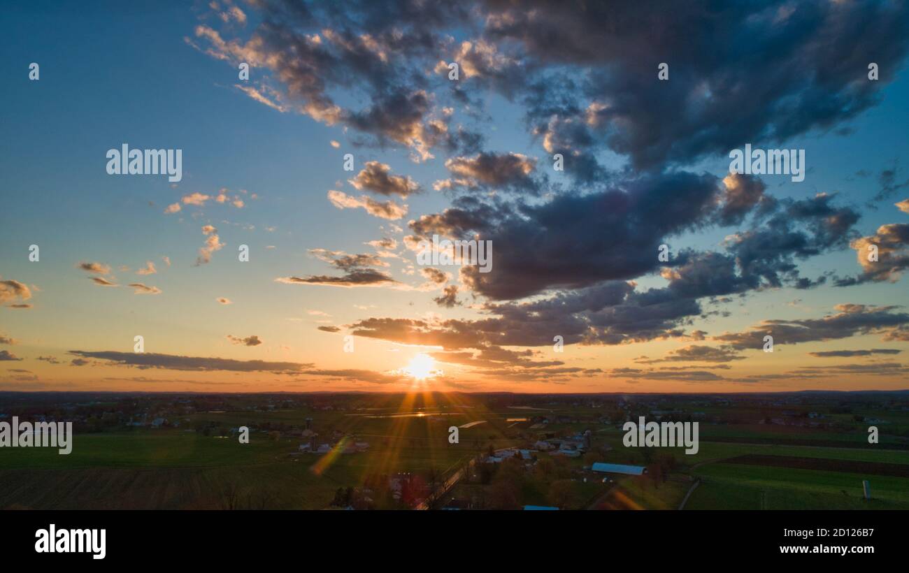 Aerial view of a Sunset over barns, silos and farmlands during the ...