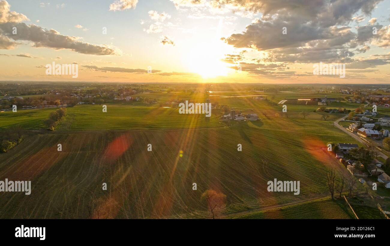 Aerial view of a Sunset over barns, silos and farmlands during the ...