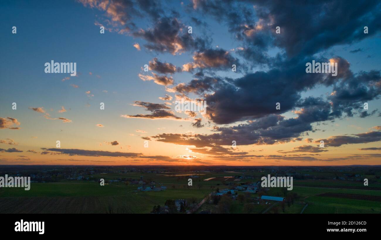Aerial view of a Sunset over barns, silos and farmlands during the ...