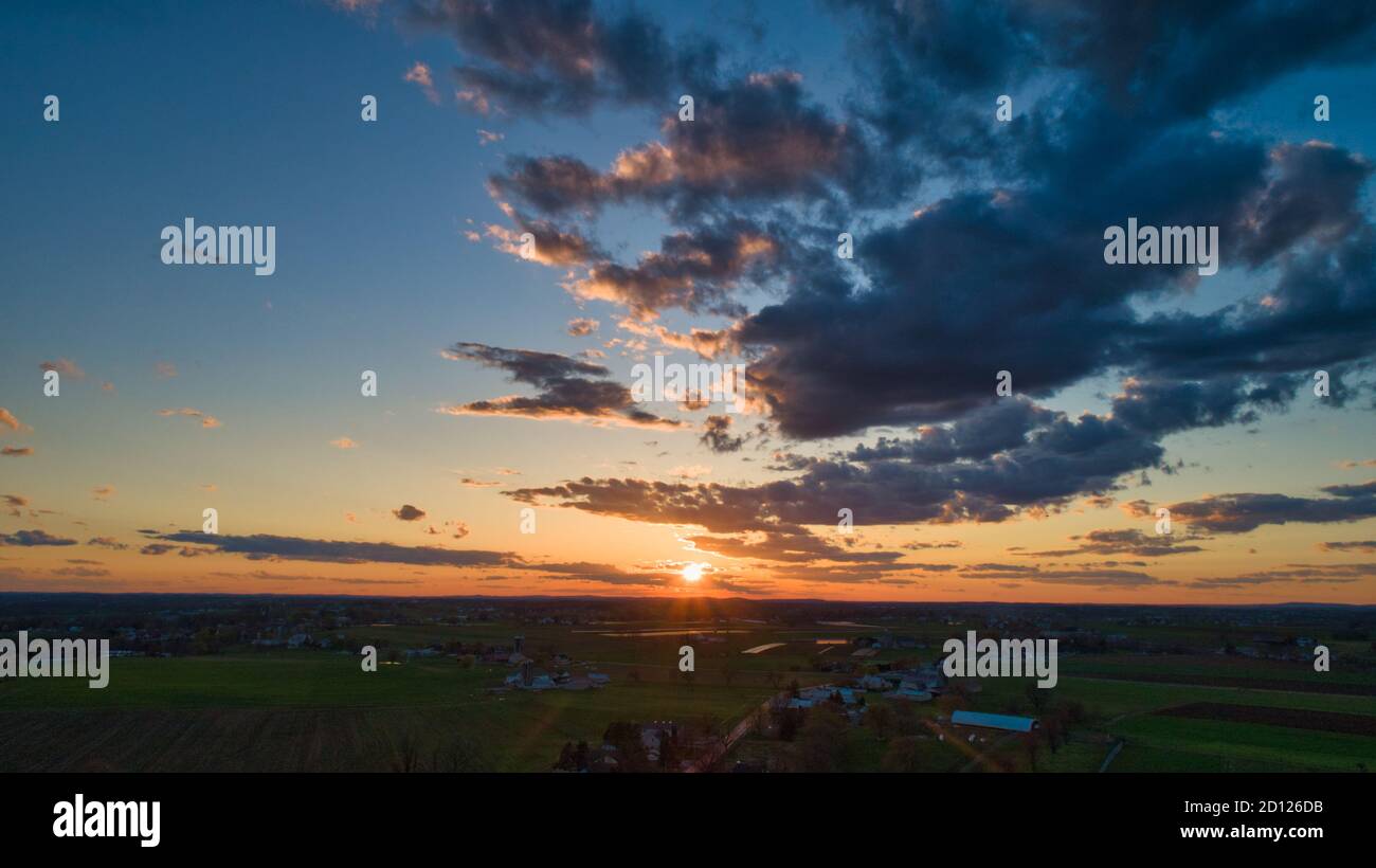 Aerial view of a Sunset over barns, silos and farmlands during the ...