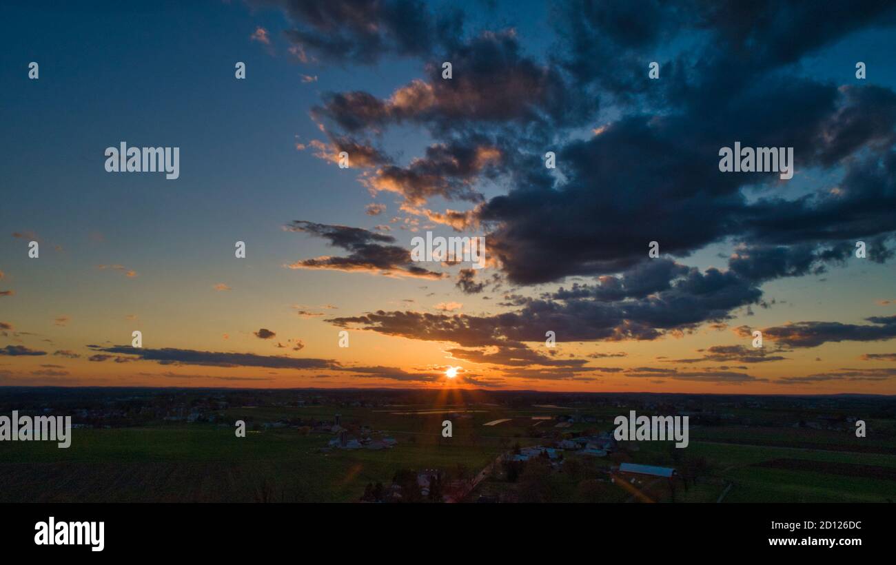 Aerial view of a Sunset over barns, silos and farmlands during the ...