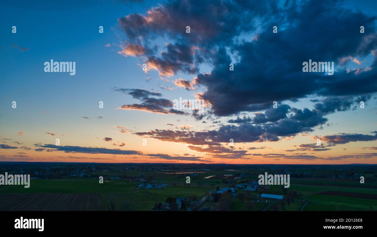 Aerial view of a Sunset over barns, silos and farmlands during the ...