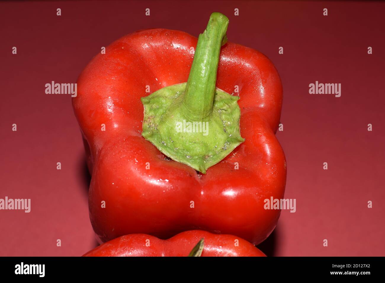 red sweet bell pepper isolated close up on red background, produce, food photography Stock Photo