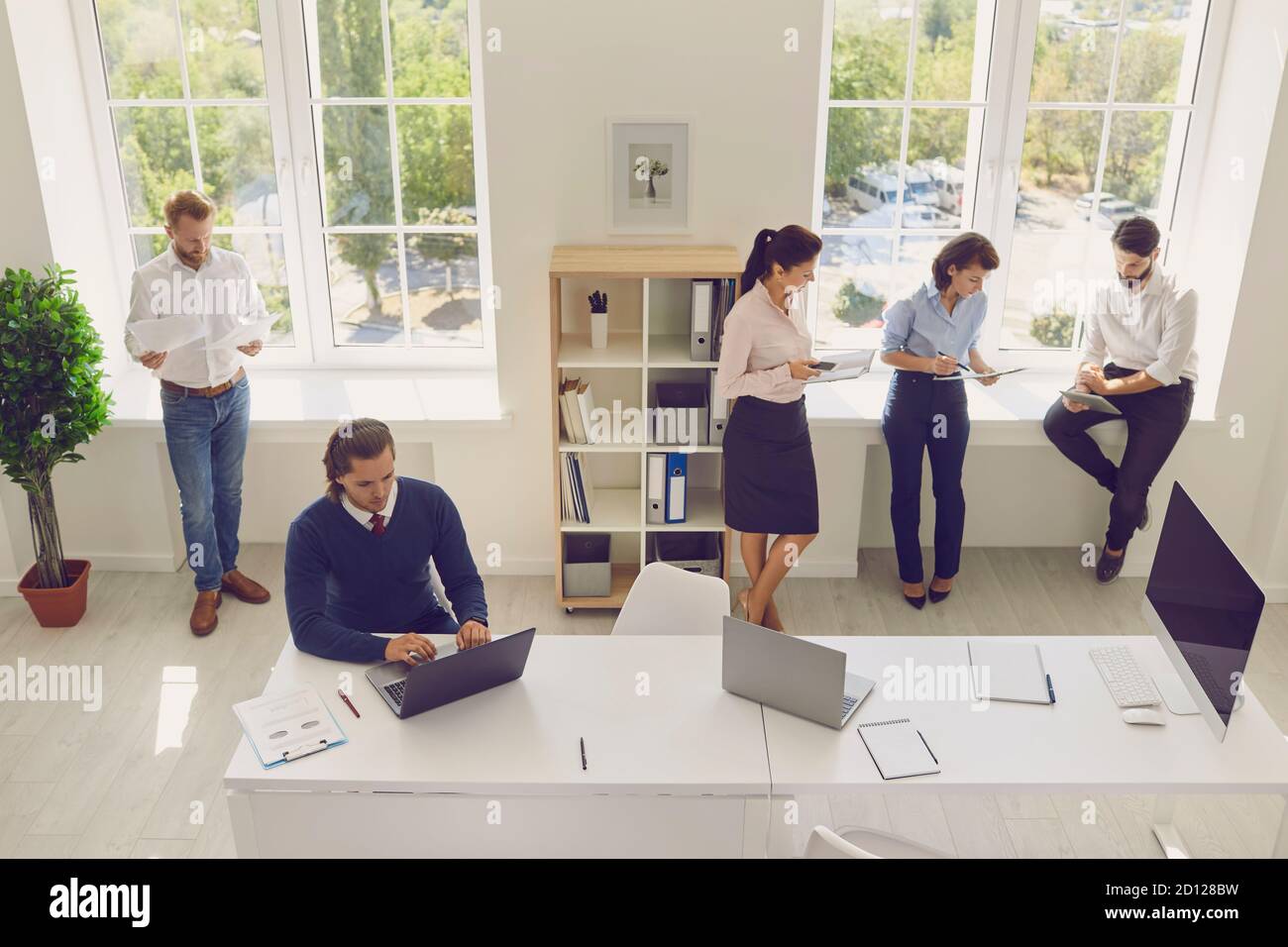 Young concentrated creative coworkers working with new startup project in modern office. Stock Photo