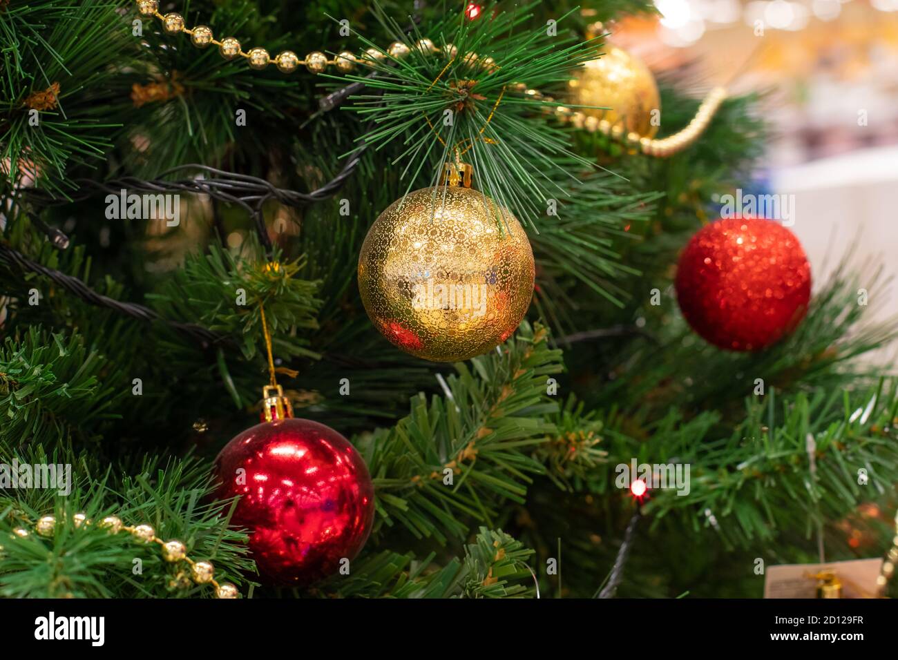 Christmas tree decorated with shining red gold balls close-up. Festive ...